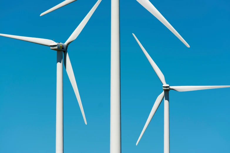 a group of wind turbines against a blue sky, a portrait, unsplash, dan munford, detailed high resolution, white, maintenance photo