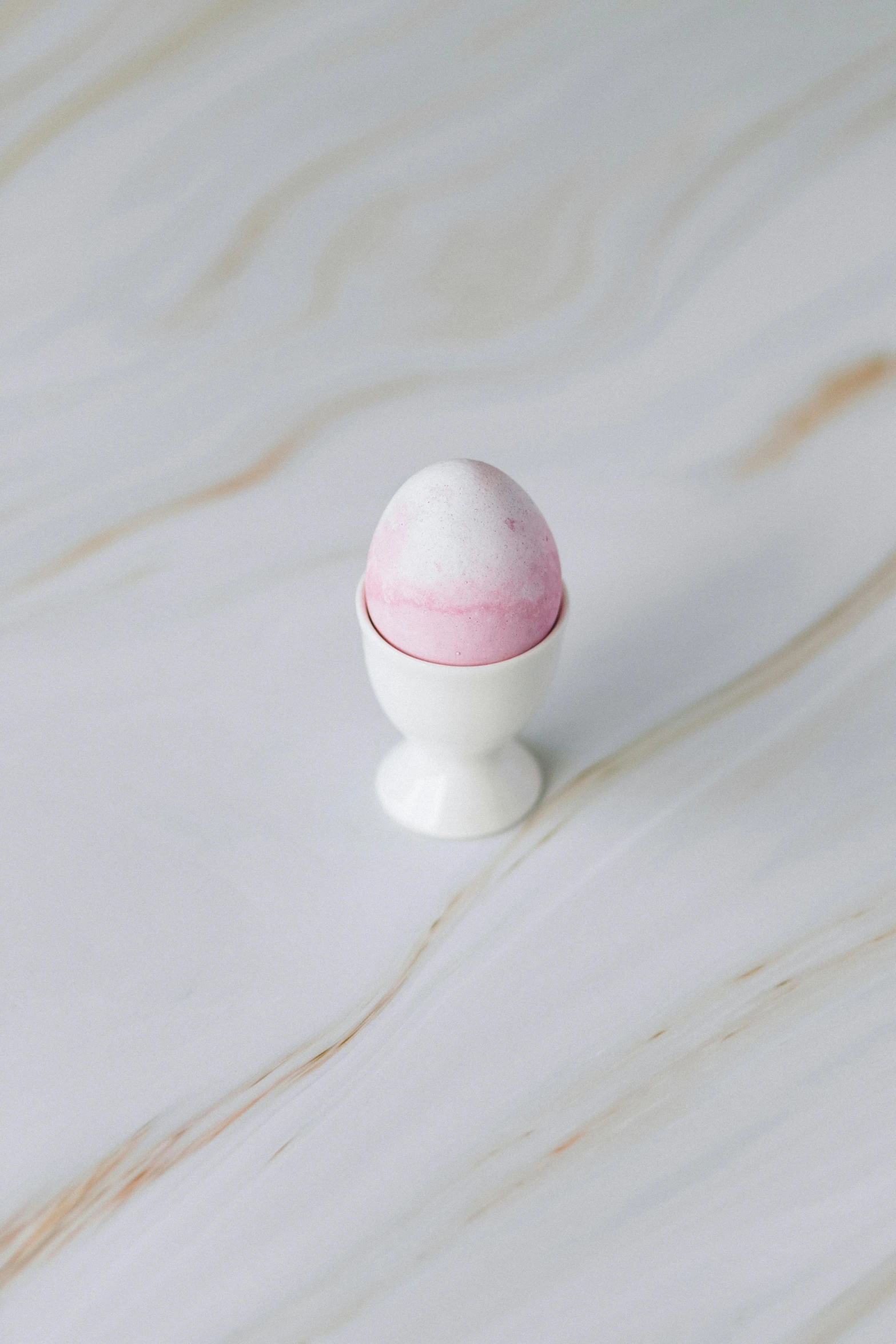 a white egg sitting on top of a marble table, pink mist, miniature product photo, epicurious, white finish