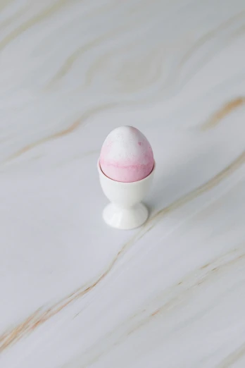 a white egg sitting on top of a marble table, pink mist, miniature product photo, epicurious, white finish