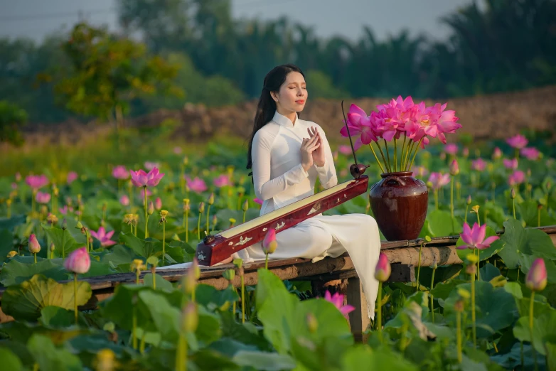 a woman sitting in a field of pink flowers, an album cover, inspired by Cui Bai, sitting in a small bamboo boat, standing gracefully upon a lotus, 2022 photograph, 8 k 4 k