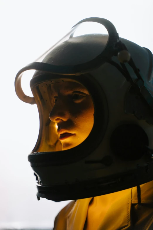 a close up of a person wearing a helmet, unsplash, fantastic realism, diving suit, perfectly lit. movie still, resin, backlit face