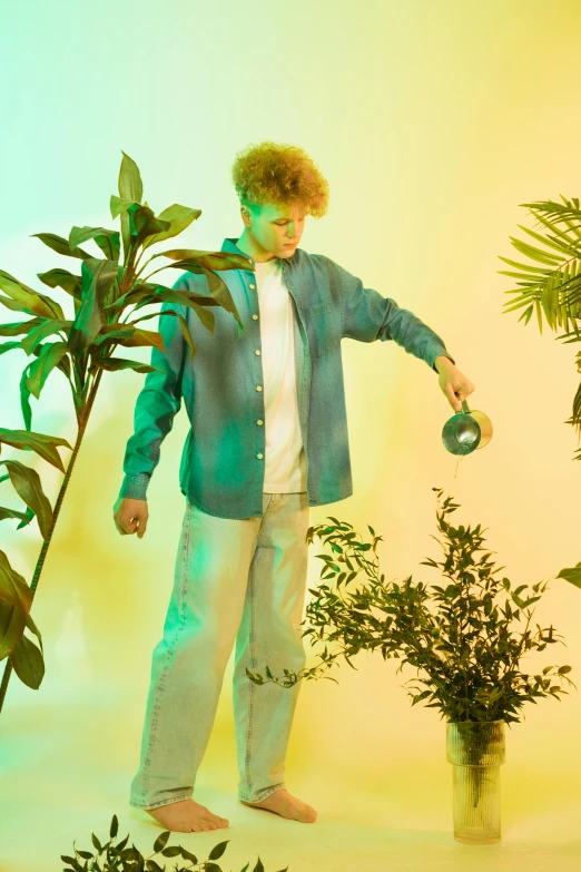 a man standing next to a potted plant, an album cover, trending on pexels, magic realism, red haired teen boy, tropical lighting, very very curly blond hair, cyan and green