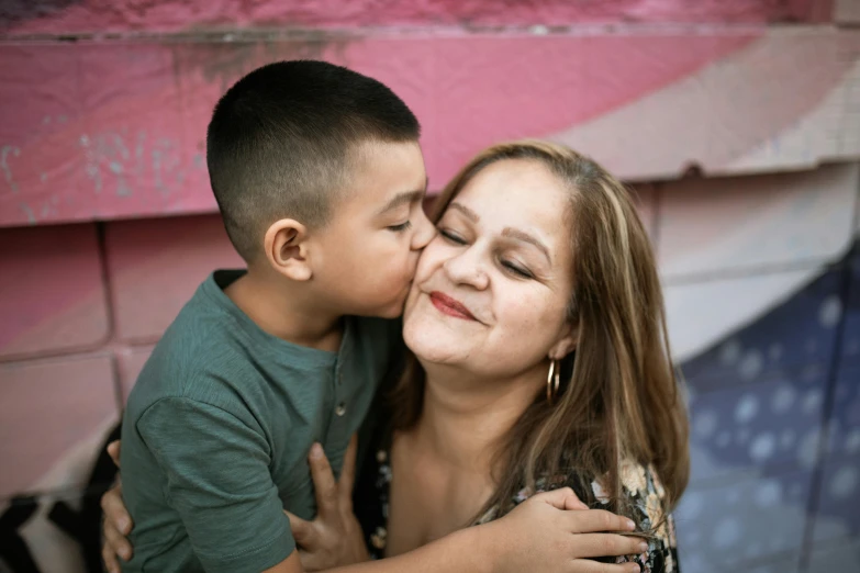 a woman giving a boy a kiss on the cheek, pexels contest winner, hispanic, fan favorite, high quality portrait, strong presense