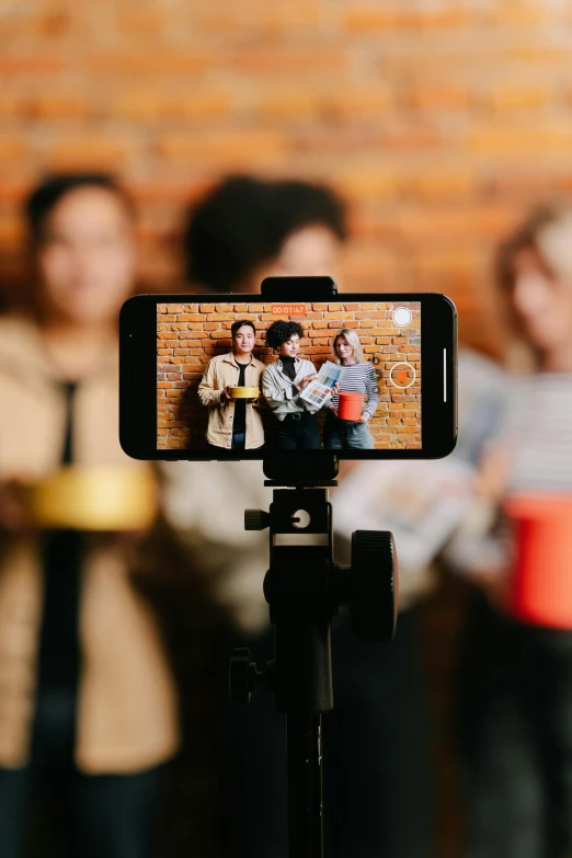 a person taking a picture of a group of people, trending on pexels, video art, movie promotional image, home video, college, modeled