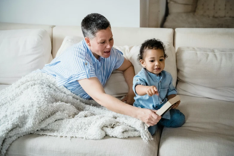 a woman reading a book to a child on a couch, diverse, instagram post, full res, rectangle