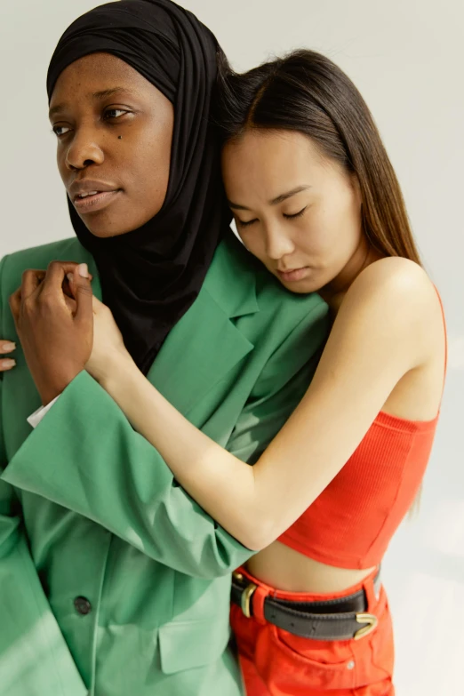 a couple of women standing next to each other, inspired by Ren Hang, trending on pexels, red green, aida muluneh, hugs, virgil abloh