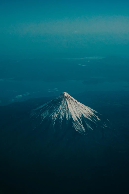 a view of a snow covered mountain from an airplane, an album cover, unsplash contest winner, mt. fuji, low light, 5 0 0 px, vulcano
