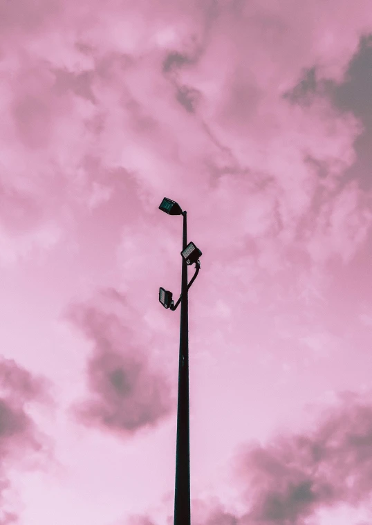 a street light with a pink sky in the background, by Carey Morris, unsplash contest winner, postminimalism, pink cloudy background, pastel goth aesthetic, 3 layers of sky above each other, sitting down