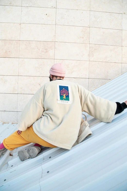 a man riding a snowboard down a snow covered slope, an album cover, inspired by Ren Hang, trending on pexels, embroidered robes, roof garden, beige hoodie, ameera al-taweel