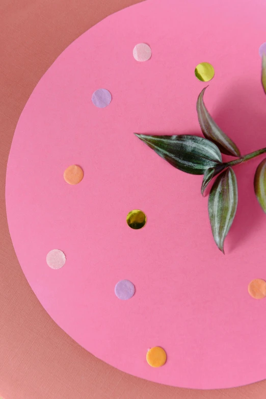 a green olive sitting on top of a pink plate, an album cover, inspired by Damien Hirst, trending on unsplash, confetti, large leaves, dots, laser cut