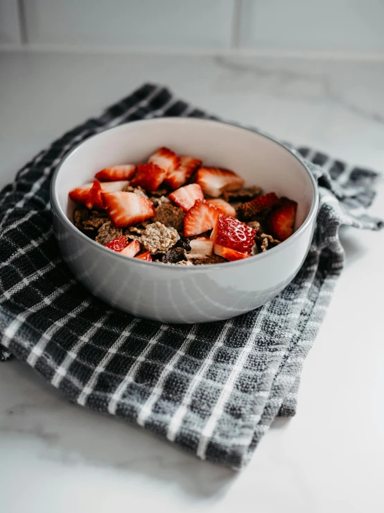 a bowl of oatmeal with strawberries on a napkin, by Kristin Nelson, unsplash, dwell, grey, bronze, flannel