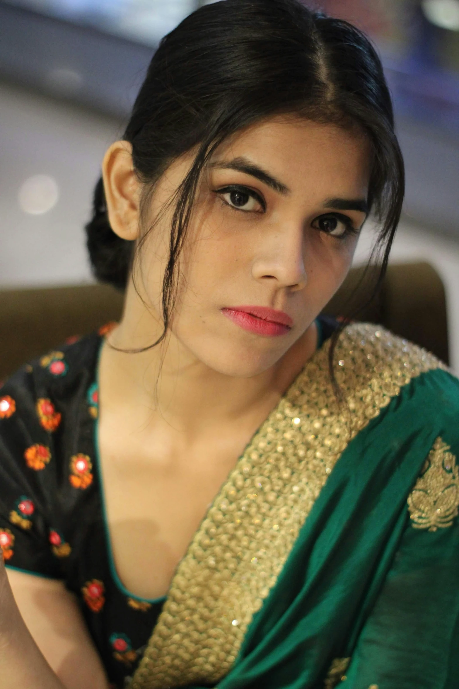 a woman in a green and gold sari, looking serious, photo of young woman, promo image, candid