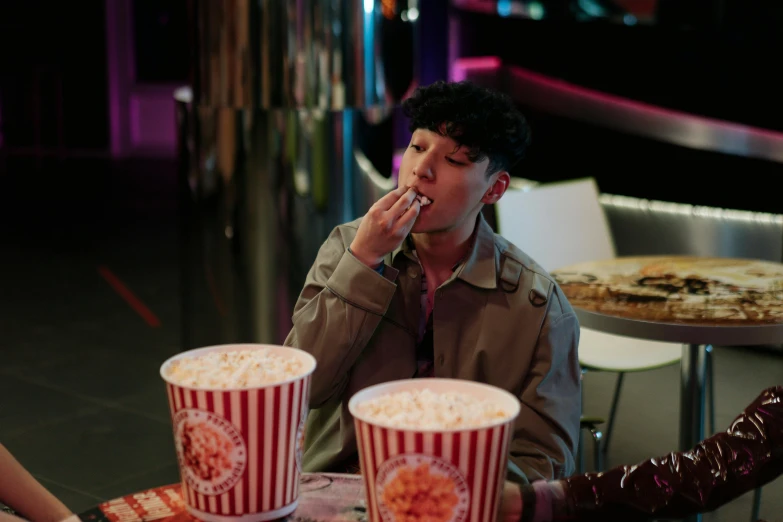 a couple of people that are sitting at a table, pexels, hyperrealism, taehyung eating gucci fries, in a cinema, cai xukun, performing a music video