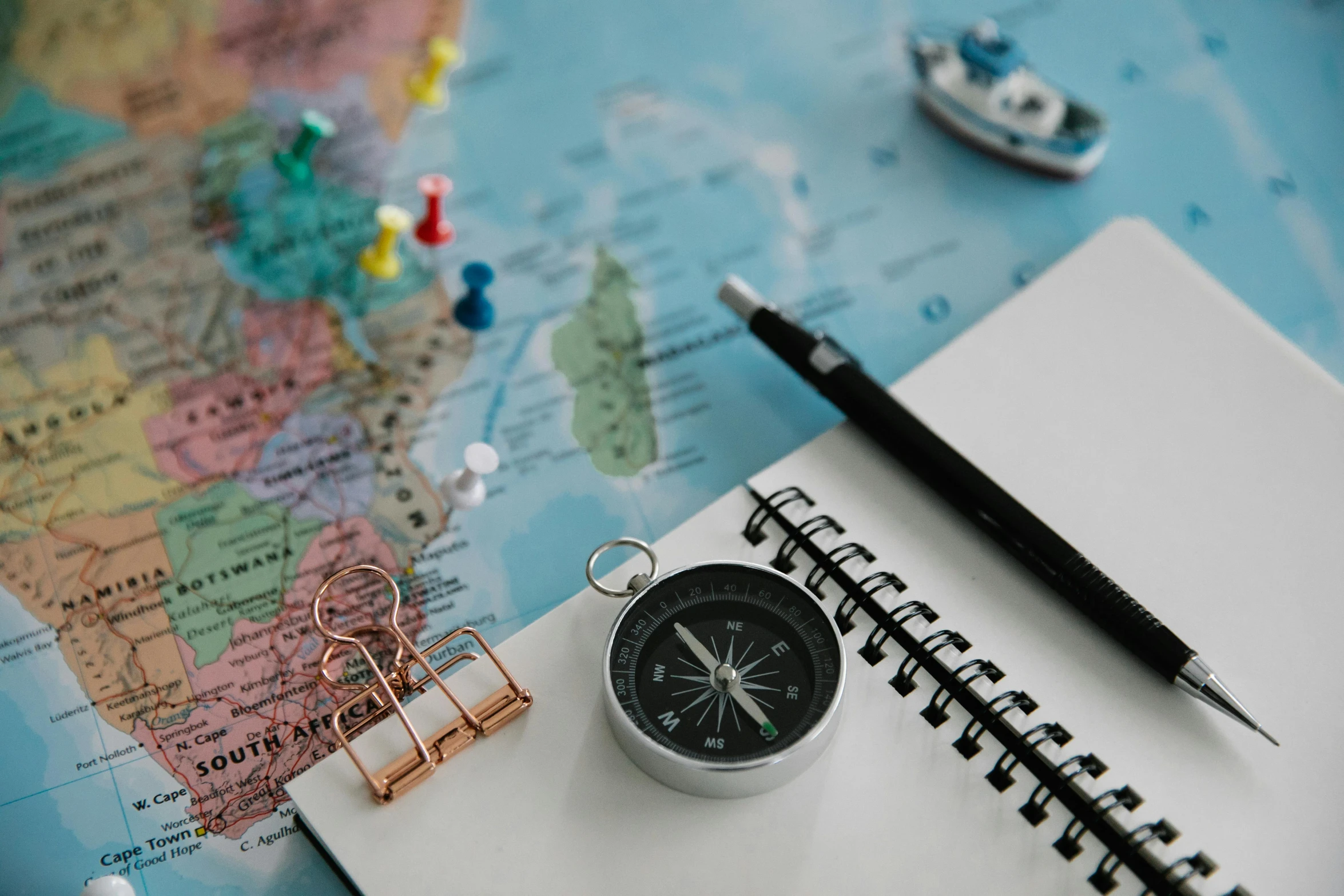 a compass sitting on top of a map next to a pen, by Julia Pishtar, pexels contest winner, boat, mini model, drawing pictures on a notebook, modeled