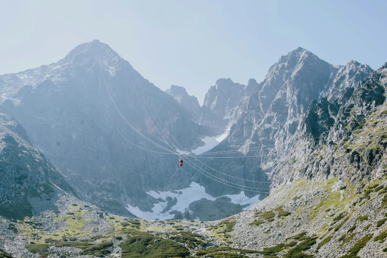 a person flying a kite in the mountains, by Emma Andijewska, pexels contest winner, minimalism, gondola, avatar image, panorama view, still from a wes anderson film