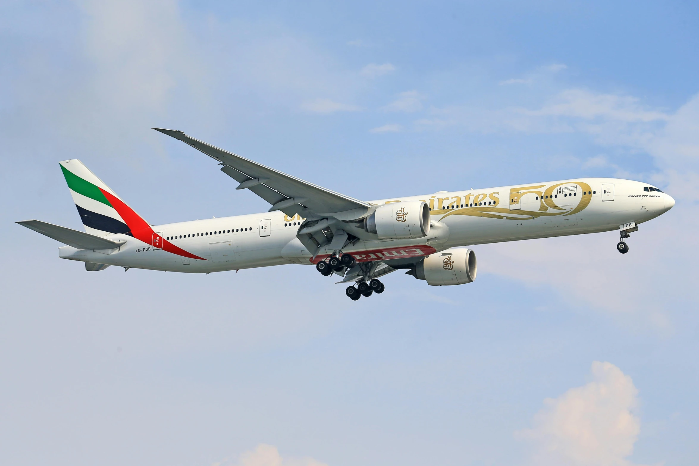a large passenger jet flying through a blue sky, a picture, arabesque, gold and red accents, long tails, advanced economy, golden eal