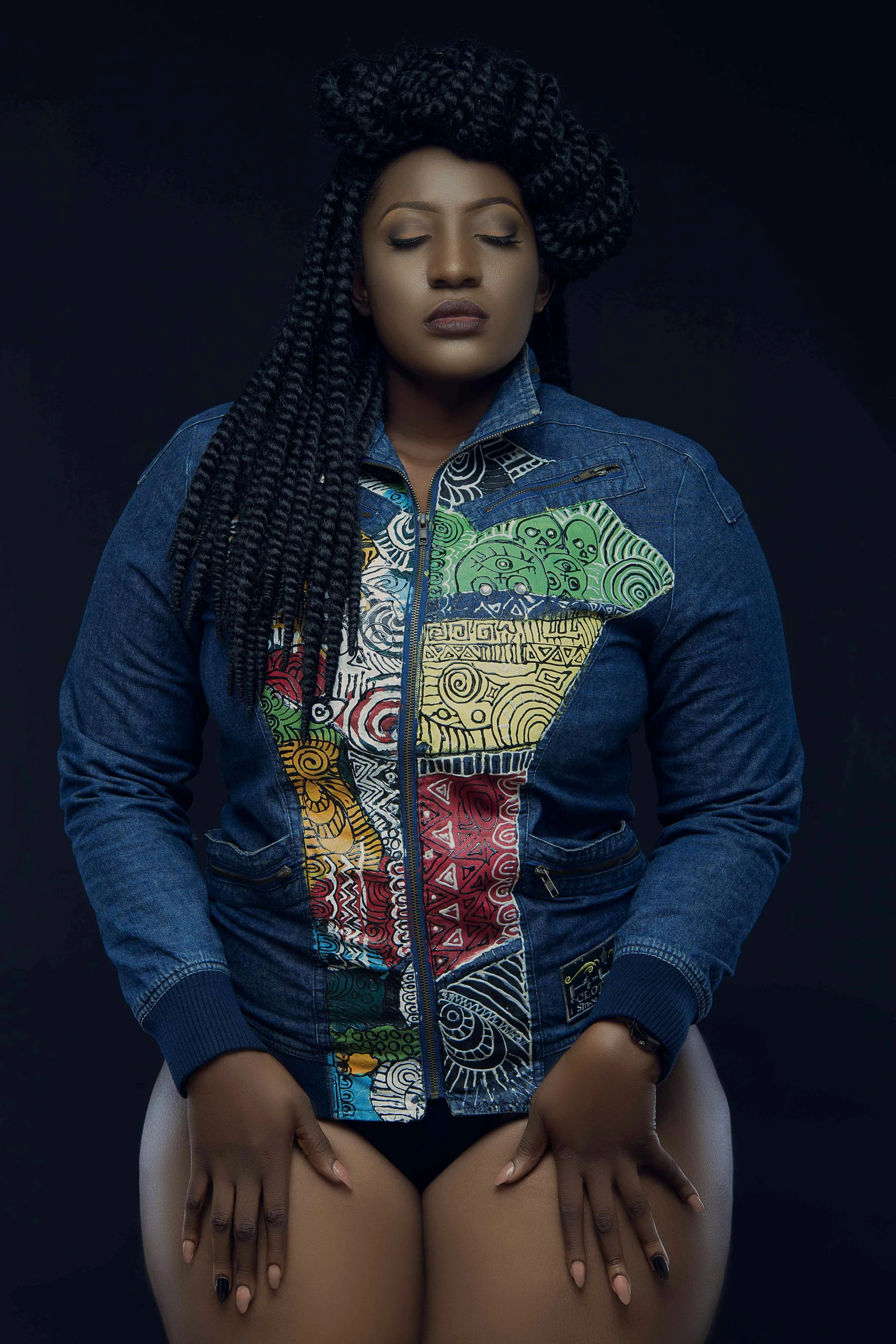 a woman sitting on top of a chair, by Lily Delissa Joseph, pexels contest winner, afrofuturism, cropped shirt with jacket, plus size, wearing a jeans jackets, patterned clothing