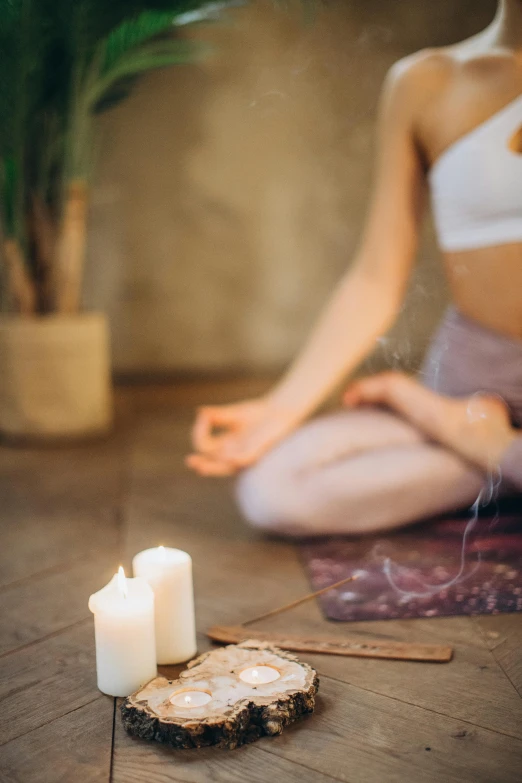 a woman sitting on the floor in front of a candle, trending on pexels, renaissance, yoga, on the altar, light haze, smoking with squat down pose