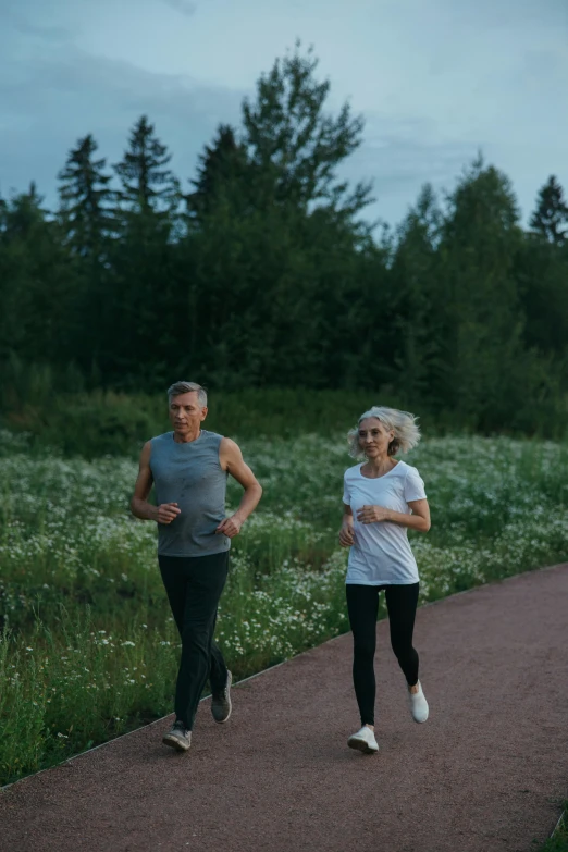 a couple of people that are running on a path, by Jaakko Mattila, in the evening, healthcare, profile image, lush surroundings