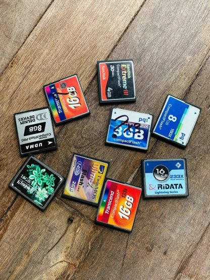 a pile of memory cards sitting on top of a wooden floor, a picture, computer art, sci fi data readouts, 8 0 s camera, game pack, 1.8f