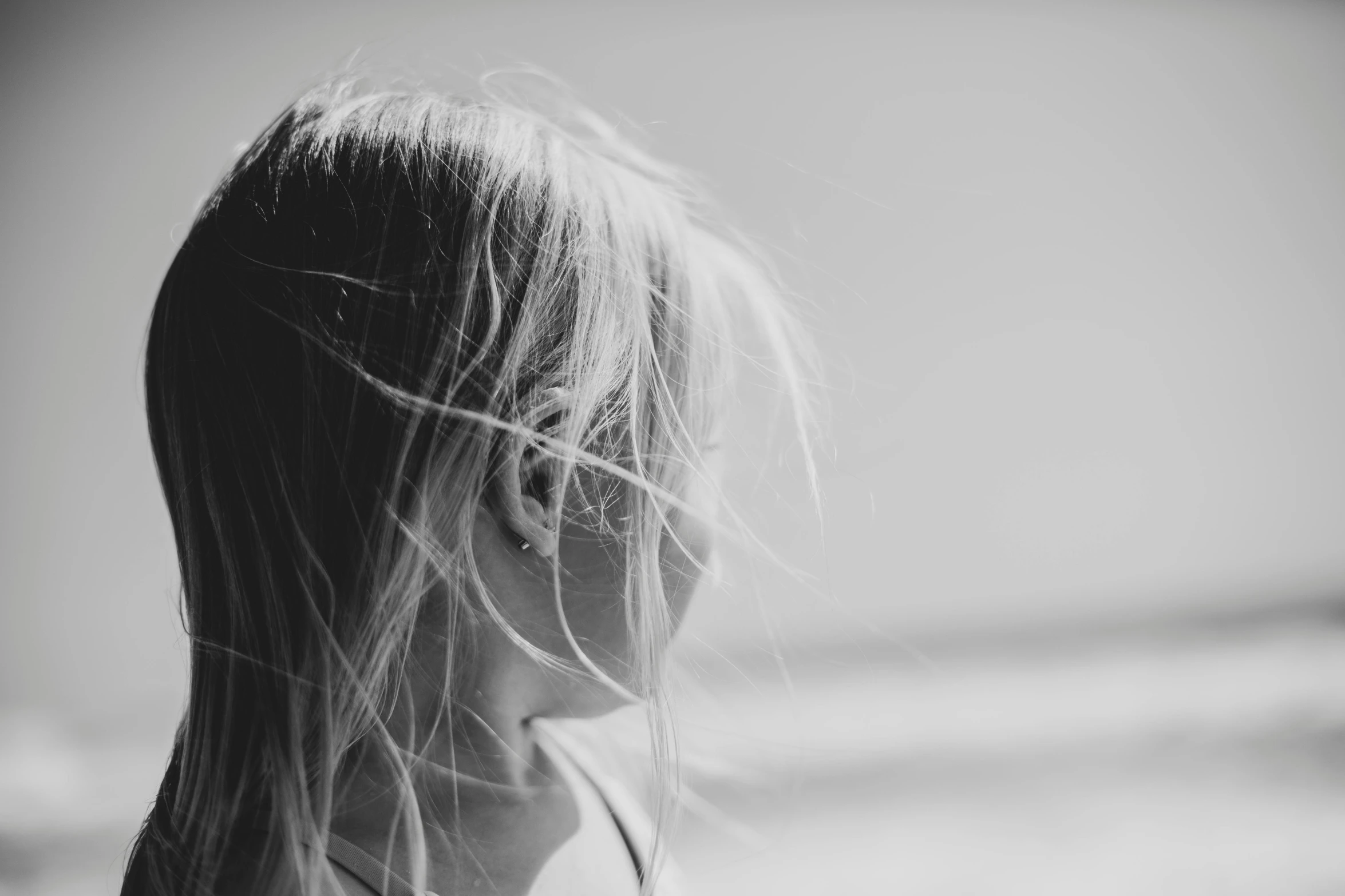 a black and white photo of a little girl on the beach, unsplash, messy hair bedhead, profile image, human head with blonde hair, soft window light