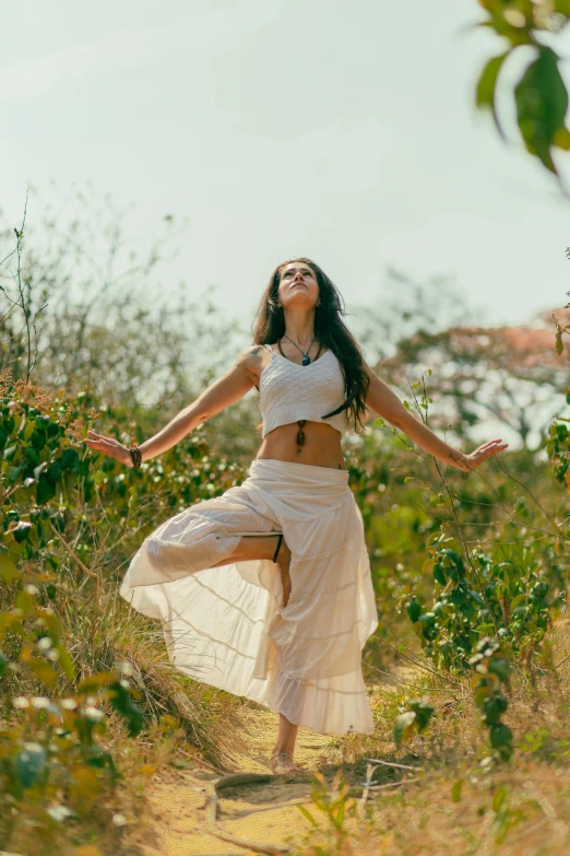 a woman that is standing in the grass, dance meditation, wearing white skirt, in jungle, 5 0 0 px models