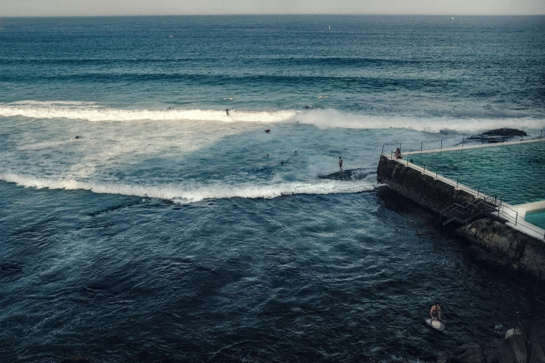 a body of water with people swimming in it, by Daniel Lieske, pexels contest winner, happening, manly, wall of water either side, surfing, people angling at the edge