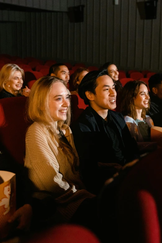 a group of people sitting in a movie theater, sydney sweeney, smiling, [ theatrical ], single subject