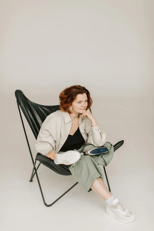 a woman sitting in a chair talking on a cell phone, an album cover, by Grytė Pintukaitė, trending on pexels, casual pose, slight overcast, redhead woman, older woman