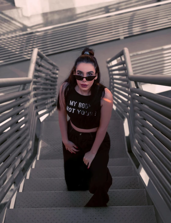 a woman sitting on a set of stairs, inspired by Ion Andreescu, trending on pexels, wearing crop top, dark shades, “uwu the prismatic person, walking towards the camera