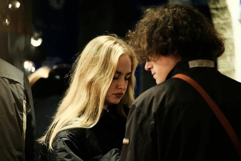 a couple of people standing next to each other, by Anato Finnstark, pexels contest winner, process art, with long blond hair, studious chiaroscuro, julia garner, concert