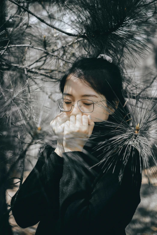 a woman blowing her nose in the woods, inspired by Yu Zhiding, pexels contest winner, with square glasses, mai anh tran, pensive lonely, black