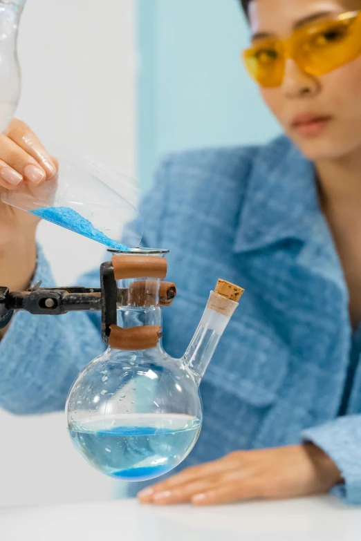 a woman is doing a science experiment in a lab, an album cover, shutterstock, zoomed in, high quality photo, water particulate, japanese