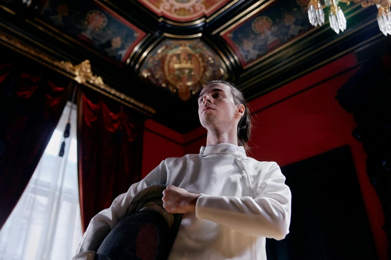 a woman standing in a room next to a chandelier, inspired by Horace Vernet, unsplash, baroque, wearing white chef hat, fencing, portrait of timothee chalamet, plating