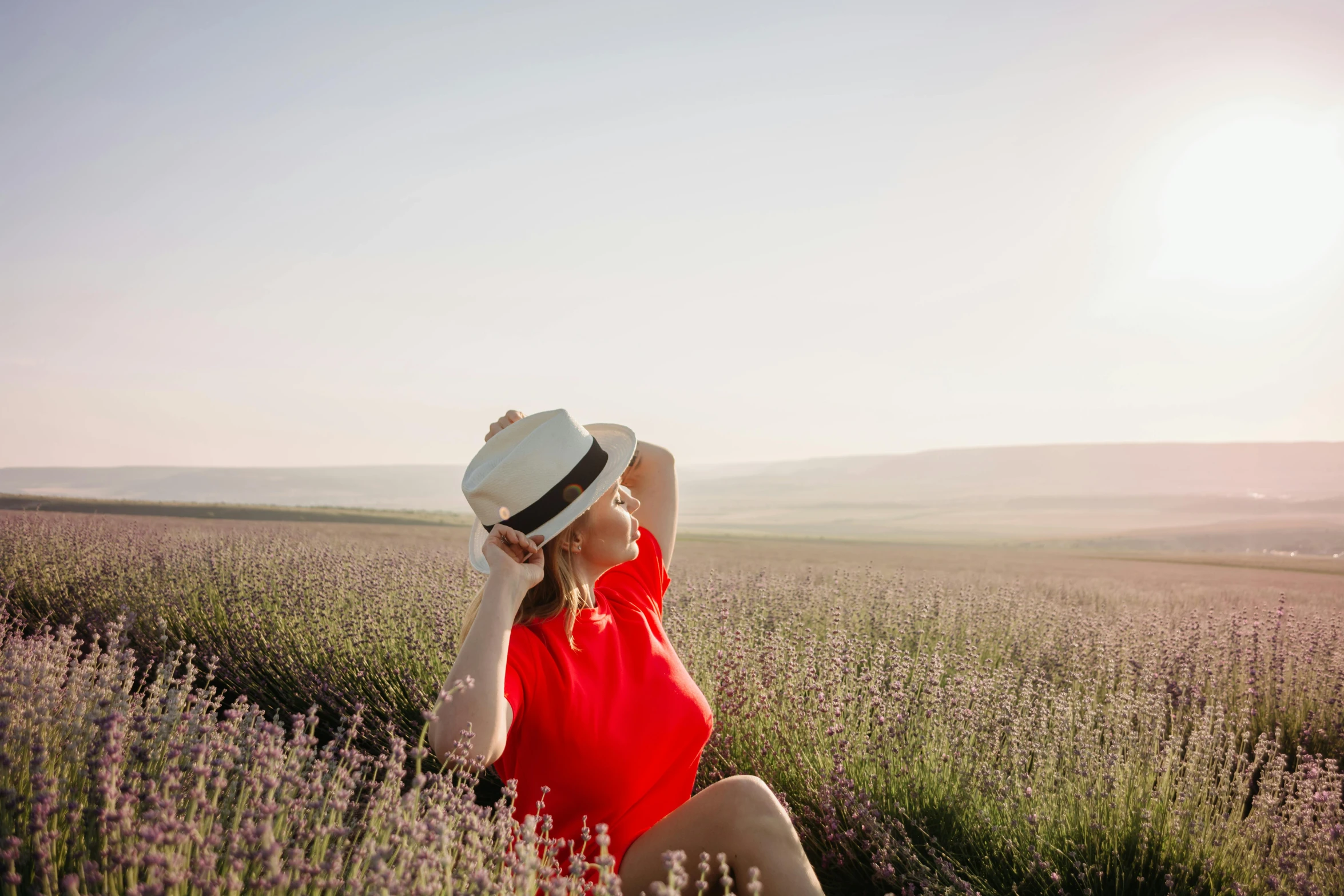 a woman in a red shirt and hat sitting in a lavender field, pexels contest winner, avatar image, background image, instagram picture, anna nikonova aka newmilky