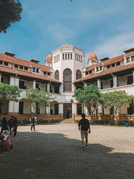 a group of people standing in front of a building, arsitektur nusantara, private school, gothic building style, courtyard walkway
