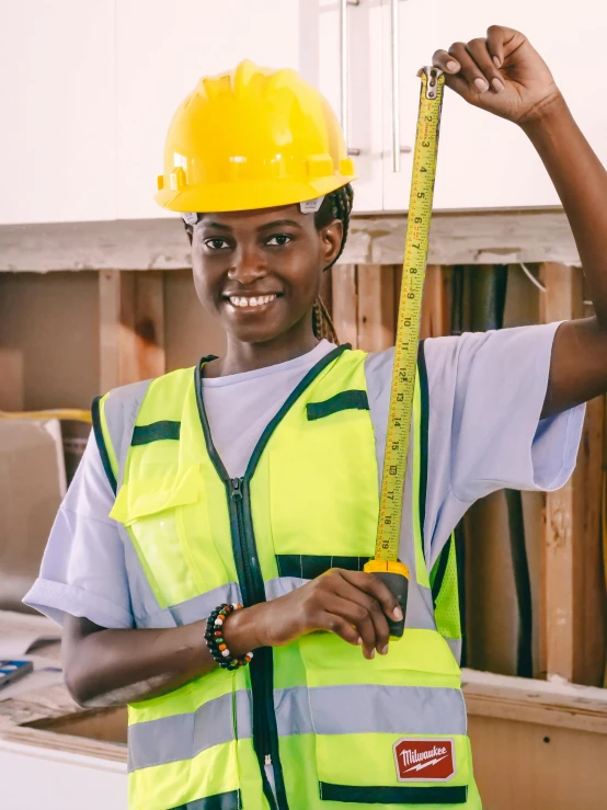 a female construction worker holding a measuring tape, inspired by Afewerk Tekle, pexels contest winner, instagram story, yellow hardhat, wearing plumber uniform, college