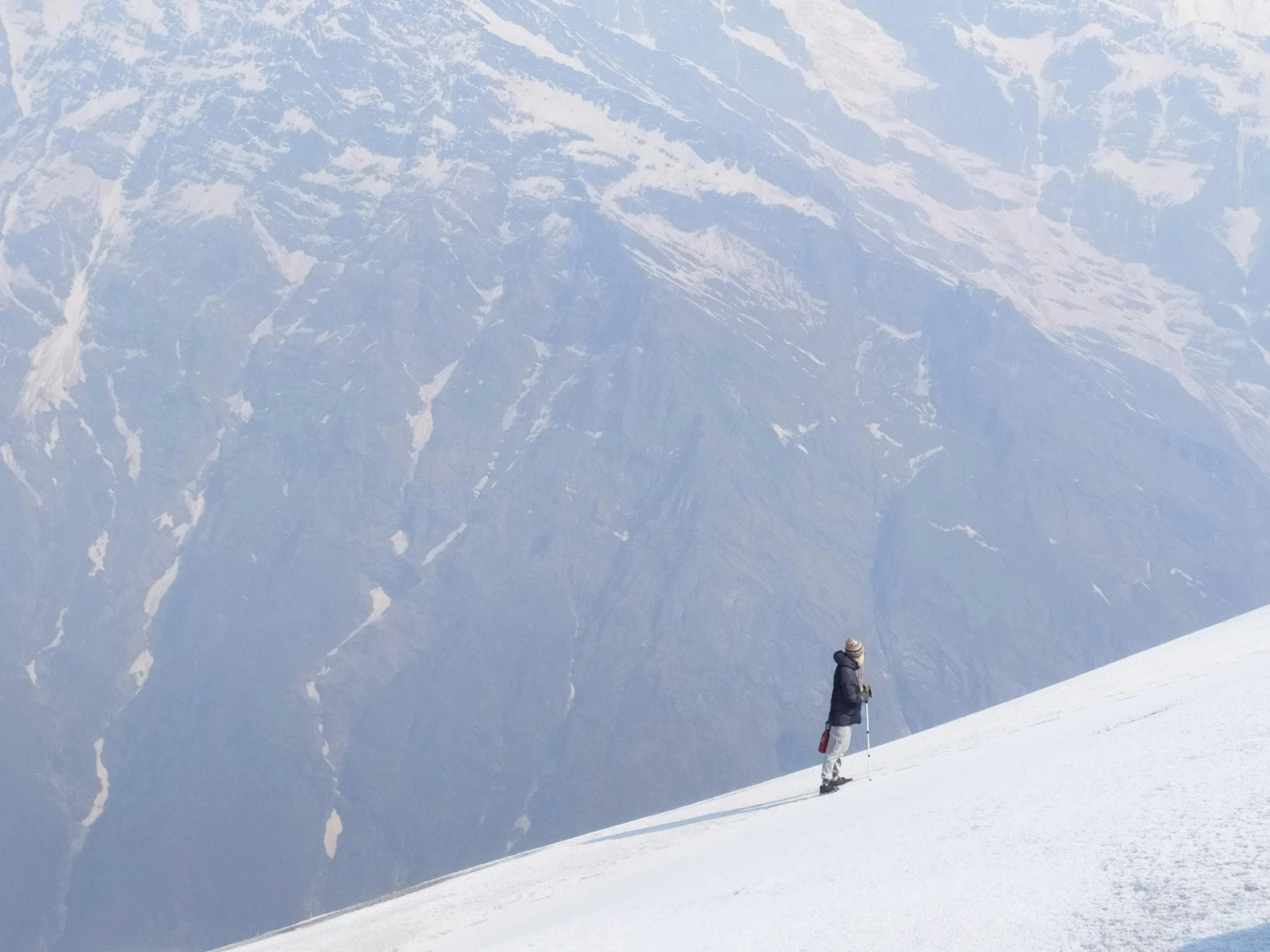 a man riding a snowboard down a snow covered slope, an album cover, inspired by jessica rossier, pexels contest winner, view(full body + zoomed out), uttarakhand, people walking around, image from afar