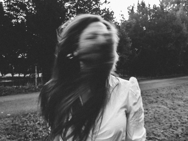 a black and white photo of a woman with long hair, a black and white photo, by Emma Andijewska, tumblr, spinning whirlwind, tired haunted expression, running freely, instagram picture