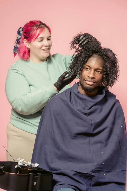 a woman getting her hair done by a hair stylist, an album cover, by Winona Nelson, featured on instagram, renaissance, east african man with curly hair, non-binary, color studio portrait, creating a soft