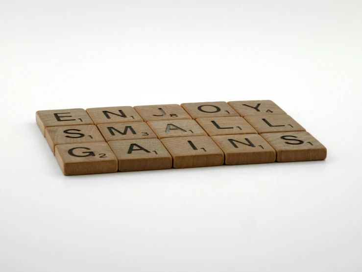 a scrabble board that says enjoy small gains, letterism, beige, single, press, brown