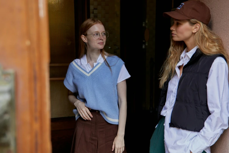 a couple of women standing next to each other, a picture, inspired by Maud Naftel, trending on cg society, wearing a school uniform, on set, brown, uncropped