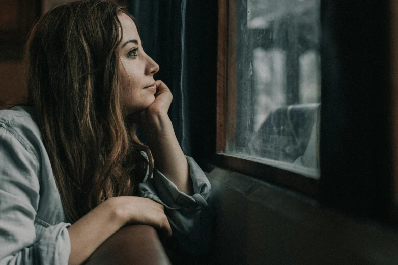 a woman sitting on a bench looking out a window, a portrait, pexels contest winner, thoughtful expression, sat down in train aile, 15081959 21121991 01012000 4k, heartbreak