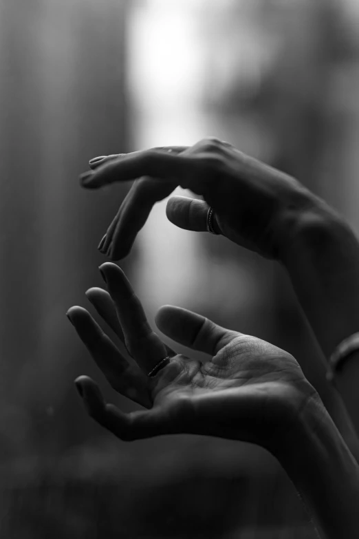 a black and white photo of a person's hands, a black and white photo, by Adam Marczyński, unsplash, play of light, manipulation, anjali mudra, pointing