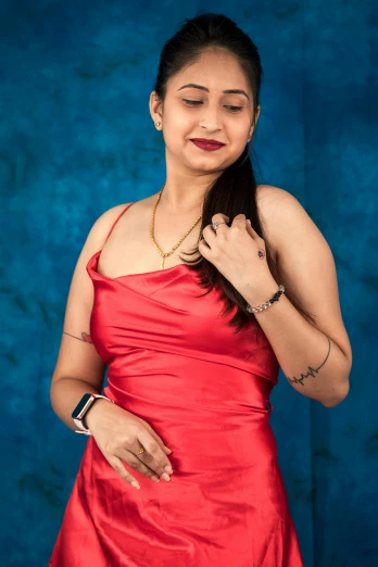 a woman in a red dress posing for a picture, provocative indian, with a blue background, profile image, portrait image