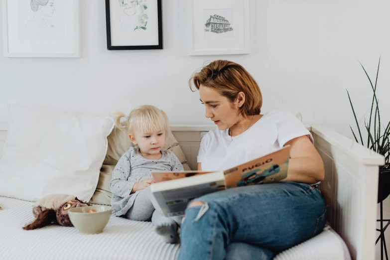 a woman reading a book to a child on a bed, by Arabella Rankin, pexels contest winner, sitting on the sofa, looking to the side, white, 15081959 21121991 01012000 4k