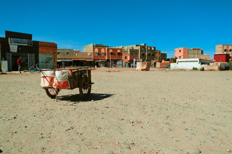 a bike that is sitting in the dirt, by Julia Pishtar, pexels contest winner, les nabis, moroccan city, cart, square, helio oiticica