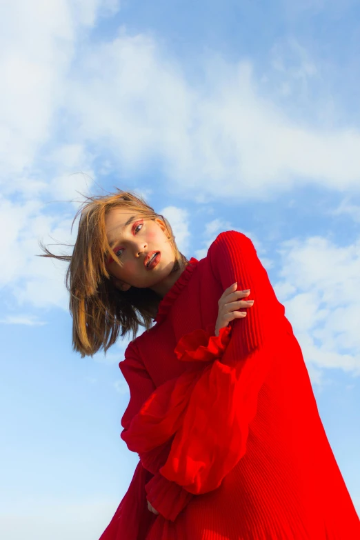 a woman in a red dress standing on a beach, an album cover, pexels contest winner, wearing a red turtleneck sweater, blue sky, kiko mizuhara, portrait of zendaya