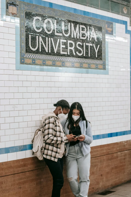 a couple of people standing next to a wall, trending on unsplash, subways, academia, zombie's, corona