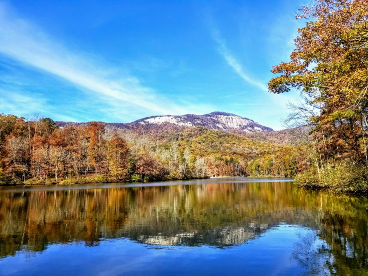 a lake surrounded by trees with a mountain in the background, by Meredith Dillman, pexels contest winner, cahaba river alabama, the fall season, multiple stories, mirrored